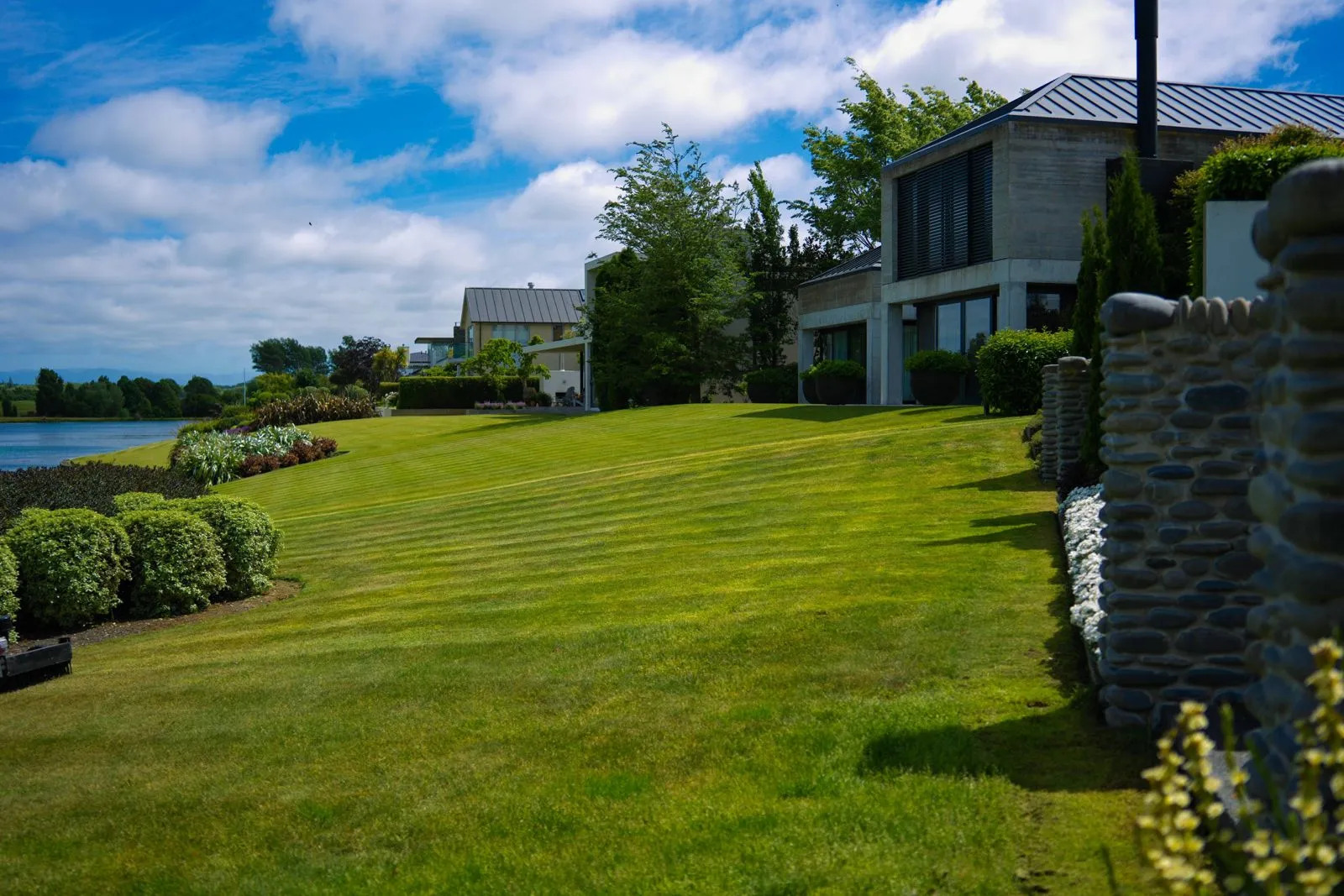 Maintained lawn and planting beside a building in a finished landscape.